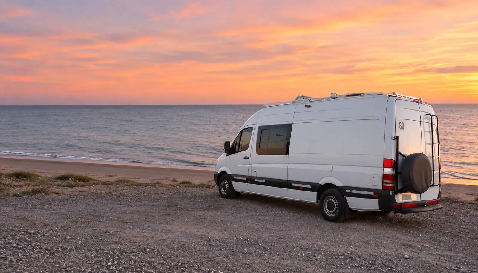 Motorhome blanco de Carrozados RF junto al mar al atardecer